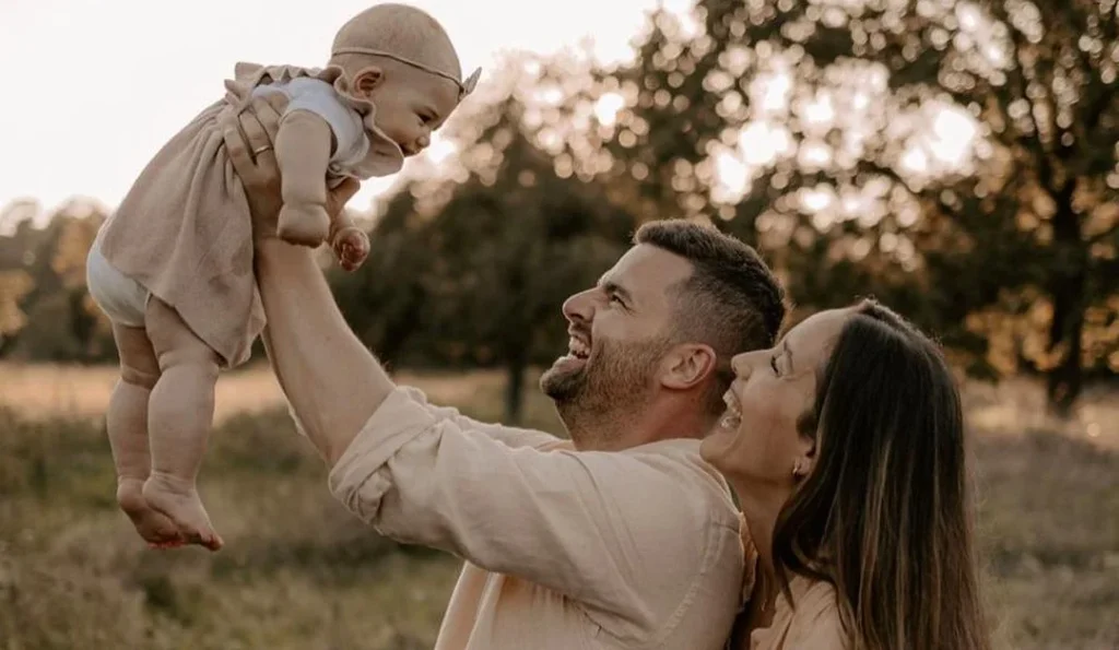 family holding a baby wearing a matching family photoshoot outfit