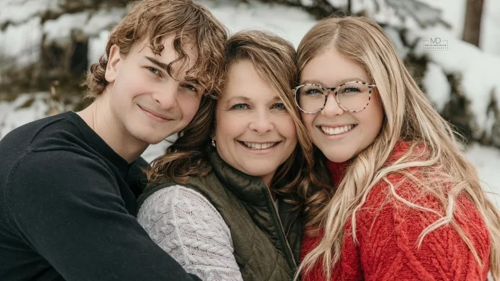 small family posing with mother and two kids in a cold winter setting