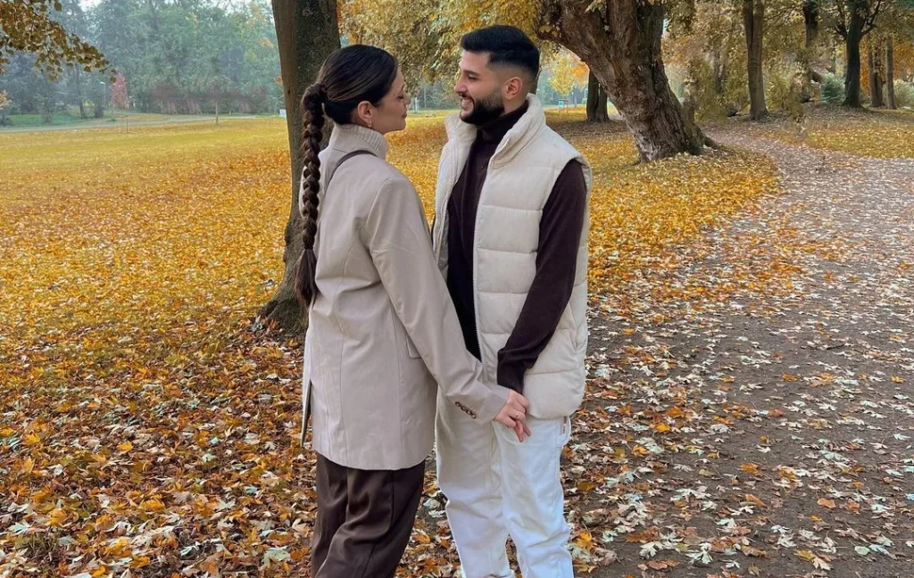 cute couple in fall setting outside golden leaves in matching grey outfits