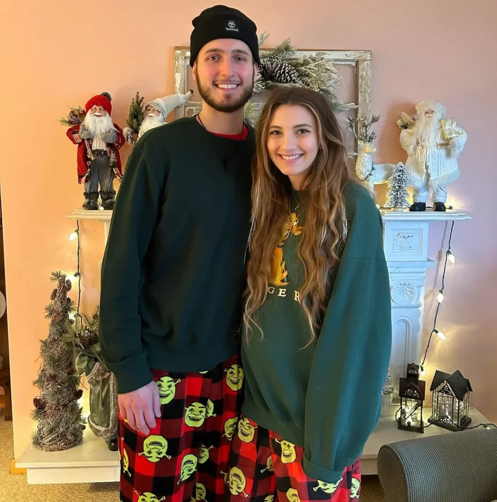 cute couple mom and dad standing and posing in their pyjamas with a shrek motif, smiling and matching outfit