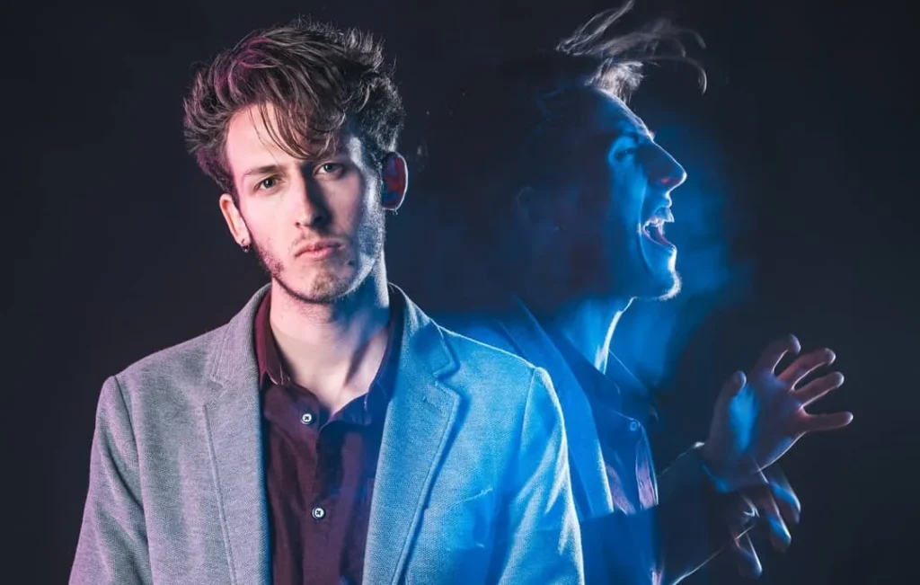 Photo of a cool looking man with a blue ghost of himself emerging from him, due to long exposure portrait photography